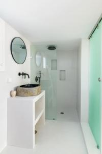 a white bathroom with a sink and a mirror at Dream House "B" in Tinos Town