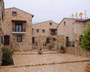 un gran edificio de piedra con un patio con escaleras en Lithea mountain resort and spa en Florina