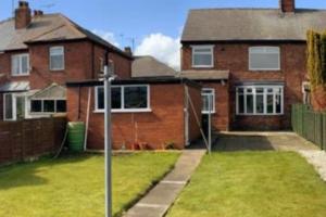 a brick house with a yard with a fence at Wishbone House in Bridlington