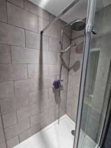 a shower with a glass door in a bathroom at Wishbone House in Bridlington