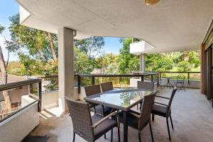 a patio with a table and chairs on a balcony at The Commodore in Nelson Bay