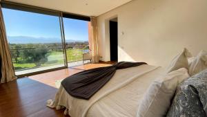 ein Schlafzimmer mit einem großen Bett und einem großen Fenster in der Unterkunft Villa Les Palmiers De L'atlas in Marrakesch