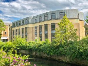un edificio con un río delante de él en New London Life Executive Apartments en Chelmsford