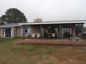 a house with a patio and a dining area at Bergview Chalet, Cathkin in Bergview