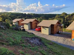 a row of wooden huts on a hill at Sítio Passo do Carro in São Francisco de Paula