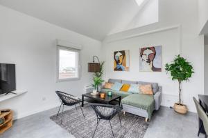 a living room with a couch and a table at Premium Flat 6 People with billard and Terrace Stade de France in Saint-Denis