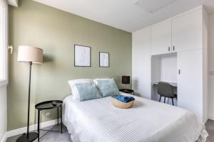 a bedroom with a white bed with a basket on it at Premium Flat 6 People with billard and Terrace Stade de France in Saint-Denis