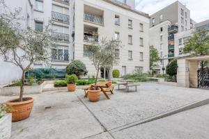 a courtyard with benches and trees in front of a building at Premium Flat 6 People with billard and Terrace Stade de France in Saint-Denis