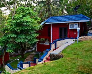 a red house with a blue staircase leading to it at VIP GARDEN RESORT in Varkala