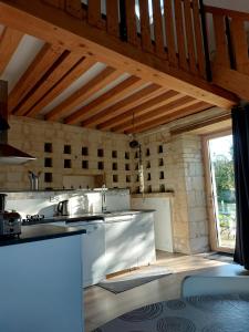 cocina con electrodomésticos blancos y techo de madera en Gîte Saumur Le Pigeonnier, Calme et Cosy, en Épieds