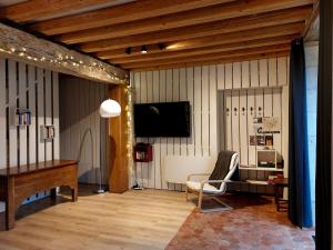 a living room with a piano and a television at Gîte Saumur Le Pigeonnier, Calme et Cosy in Épieds