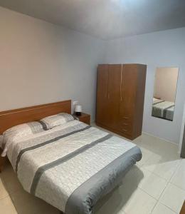 Schlafzimmer mit einem Bett und einem Holzschrank in der Unterkunft Apartments Cal Benet in Camarasa