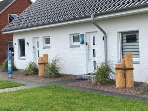 two wooden posts in front of a house at Gleich hinterm Deich 4 in Friedrichskoog
