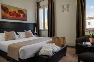 una camera con un grande letto e un divano di Hotel Helvetia Thermal Spa a Porretta Terme