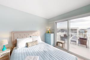 a bedroom with a bed and a balcony at Dewey Villas --- 24 Dickinson Ave, Unit #8B in Dewey Beach
