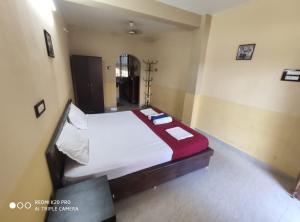 um quarto com uma grande cama branca num quarto em Regina Residency Inn em Palolem