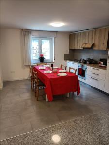 a kitchen with a table with a red table cloth at Appartamenti Primiero in Fiera di Primiero
