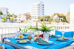 een blauwe tafel met borden eten op een balkon bij Ideal Property Mallorca - Casa Catalina in Can Picafort