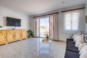 een woonkamer met een bank en een tv bij Ideal Property Mallorca - Casa Catalina in Can Picafort