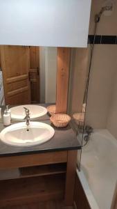 奧西耶爾的住宿－T2 cabine 6 pers au pied des pistes，浴室配有两个盥洗盆和浴缸。