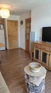 uma sala de estar com uma mesa e uma cozinha em T2 cabine 6 pers au pied des pistes em Orcières