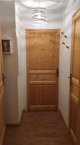 a hallway with a wooden door in a room at T2 cabine 6 pers au pied des pistes in Orcières