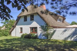 a house with a thatched roof on a yard at Dat Reethuus in Böhl