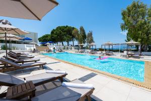 einen Pool mit Stühlen und Sonnenschirmen in einem Resort in der Unterkunft Porto Rio Hotel in Patras