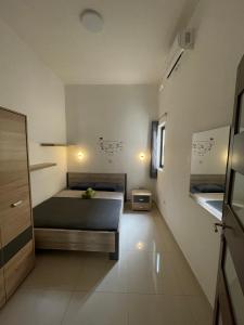 ein Schlafzimmer mit einem Bett in einem Zimmer in der Unterkunft St Orsola Apartment 2 in Victoria