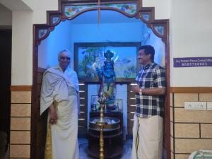 two men standing in front of a statue in a room at Krishna Kailas in Guruvāyūr