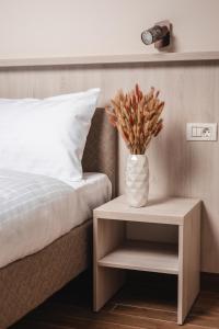 Moviliţa的住宿－Home NanoVid，睡床旁边的桌子上花瓶