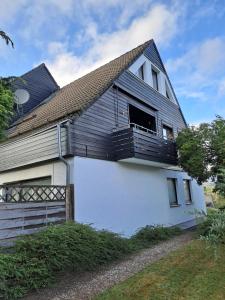 Casa in bianco e nero con balcone di Ferienwohnung Kück a Schulenberg im Oberharz