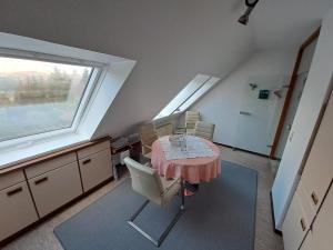 cocina con mesa, sillas y ventana en Ferienwohnung Kück, en Schulenberg im Oberharz