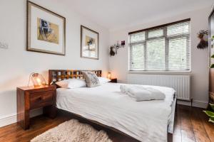 牛津的住宿－Orchard - 3 Bedroom House Headington & parking & garden，一间卧室设有两张床、一张桌子和一个窗口