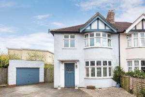 a white house with a blue garage at Orchard - 3 Bedroom House Headington & parking & garden in Oxford