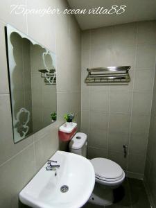 ein Badezimmer mit einem weißen Waschbecken und einem WC in der Unterkunft 75 pangkor ocean in Pulau Pangkor