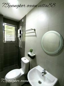 ein Badezimmer mit einem Waschbecken, einem Spiegel und einem WC in der Unterkunft 75 pangkor ocean in Pulau Pangkor
