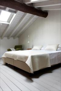 a bedroom with a large bed in a white room at Castello Oldofredi in Monte Isola