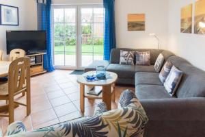 una sala de estar con un sofá y una mesa en Nordseemuschel, en Norddeich