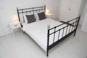 - une chambre dotée d'un lit noir avec des draps et des oreillers blancs dans l'établissement Korcula Dream spot, à Korčula