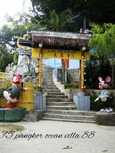 ein Tor in einem Tempel mit zwei Figuren davor in der Unterkunft 75 pangkor ocean in Pulau Pangkor