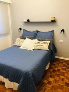 1 dormitorio con 1 cama con sábanas y almohadas azules en Departamento Recoleta I en Buenos Aires