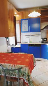 cocina con armarios azules y mesa con mantel rojo en Magic Casanova Flat in the heart of Venice, en Venecia