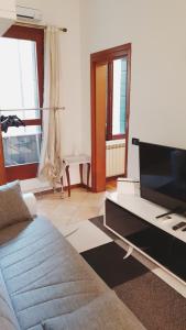sala de estar con TV y sofá en Magic Casanova Flat in the heart of Venice, en Venecia