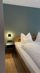1 dormitorio con 2 camas y almohadas blancas en Fairrooms - 24h Self-Check-In en Raggal