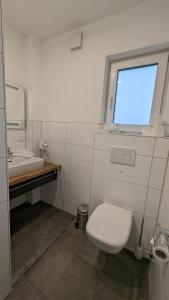 La salle de bains est pourvue de toilettes, d'un lavabo et d'une fenêtre. dans l'établissement Altes Ruderhaus, à Worms