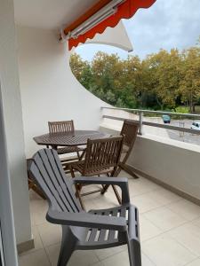 a patio with a table and chairs on a balcony at Rose côté Mer studio et garage, entrée autonome in La Grande-Motte