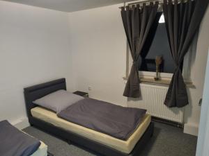 um quarto com uma cama e uma janela com cortinas em Gäste- und Geschäftswohnung Leuna em Leuna
