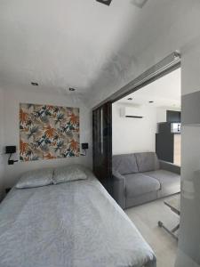 - une chambre avec un grand lit et un canapé dans l'établissement CAP'NOMAD Studio Côté Mer - balcon - piscine - parking, au Cap d'Agde