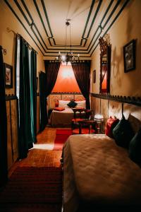 Riad Hotel Sherazade في مراكش: غرفة فندقية بسريرين وطاولة